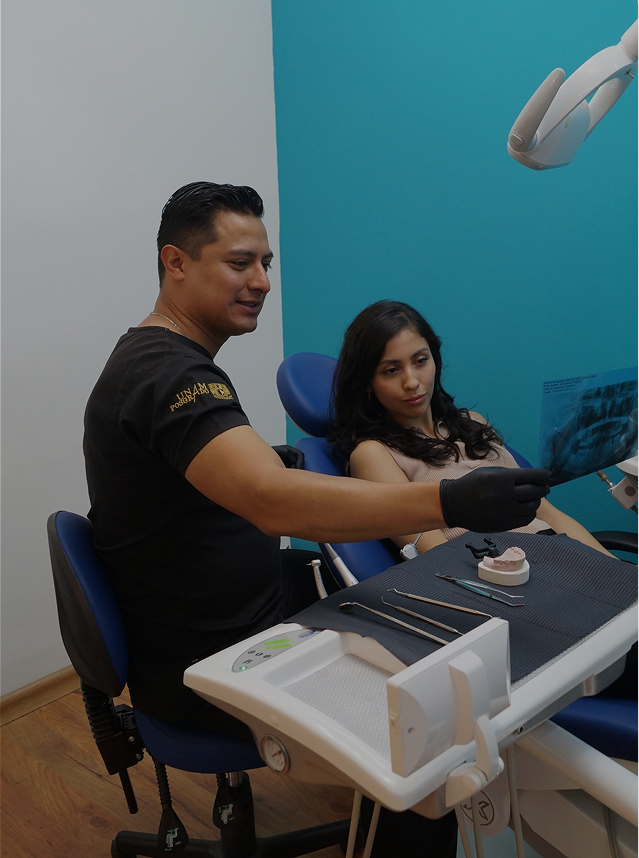 Dentista mostrando una radiografía dental a una paciente sentada en la silla del consultorio dental.